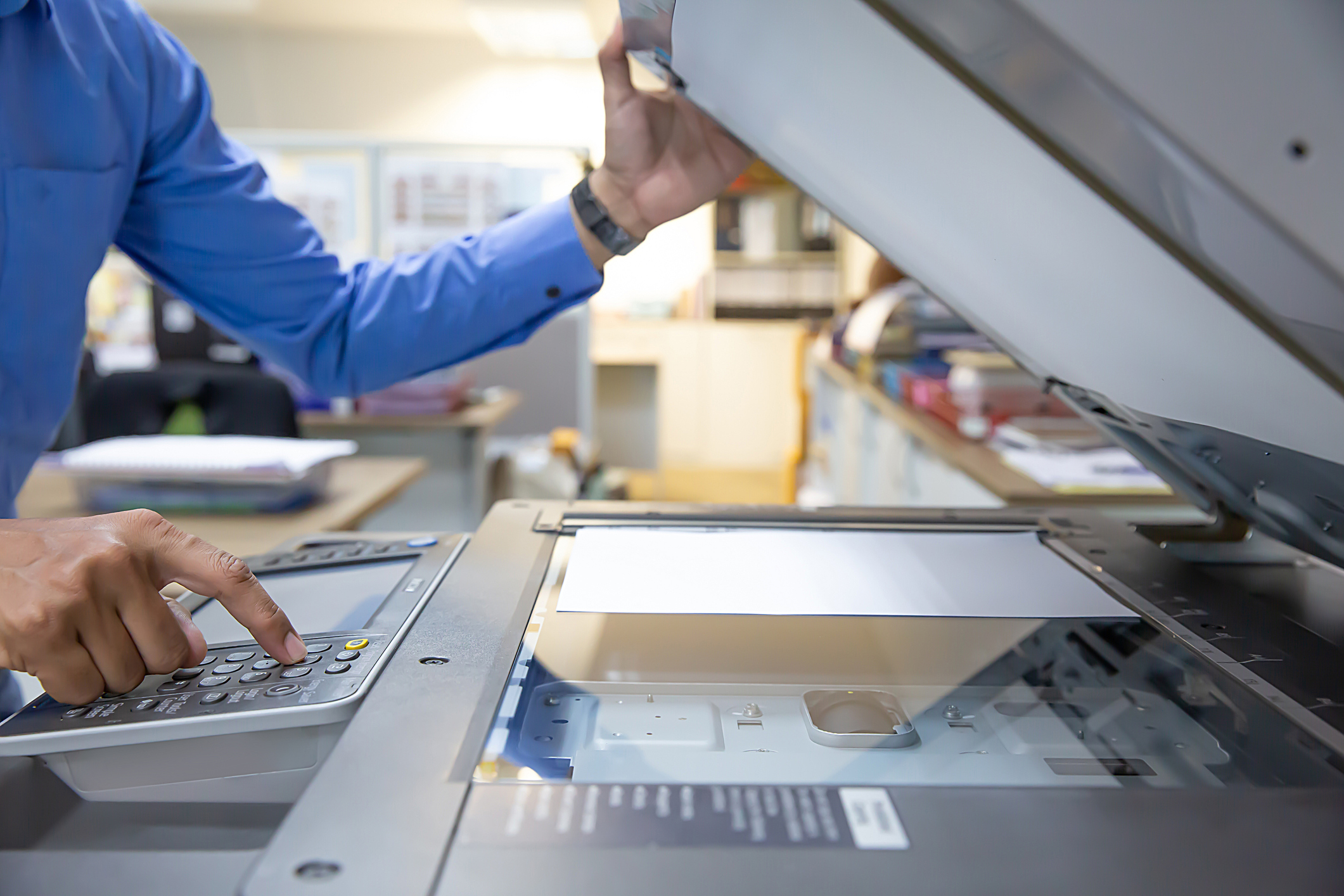 Businessmen press button on the panel of photocopier or printer for printout, scanning, exrox documents papers at office workplace.